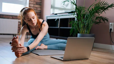 Dame tøyer ut foran laptop